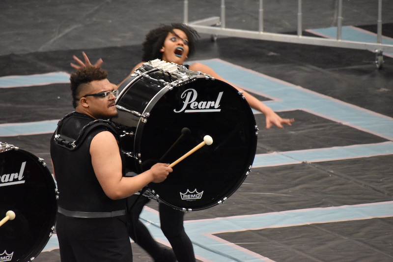 A photo of a bass drummer and dancer from Cap City 2 performing at the 2023 OIPA Marion Harding competition.