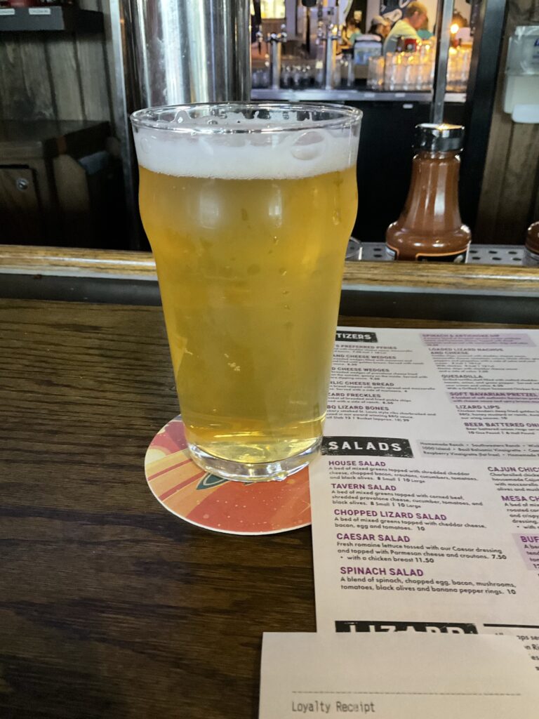 A glass of Great Lakes Kickaround​ Pog Tart Sour Ale on the bar of the Winking Lizard