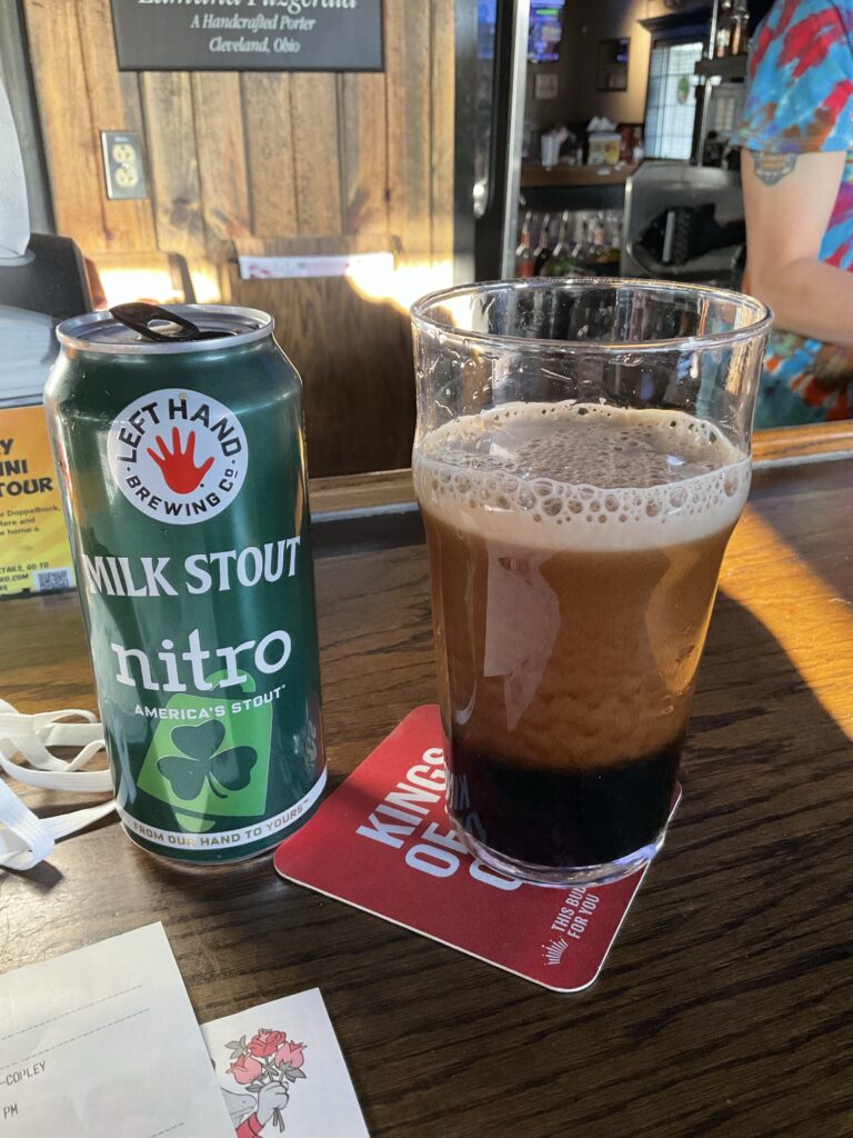 A glass of Left Hand Milk Stout Nitro on the bar at the Winking Lizard. The beer van is to the left of the glass. 