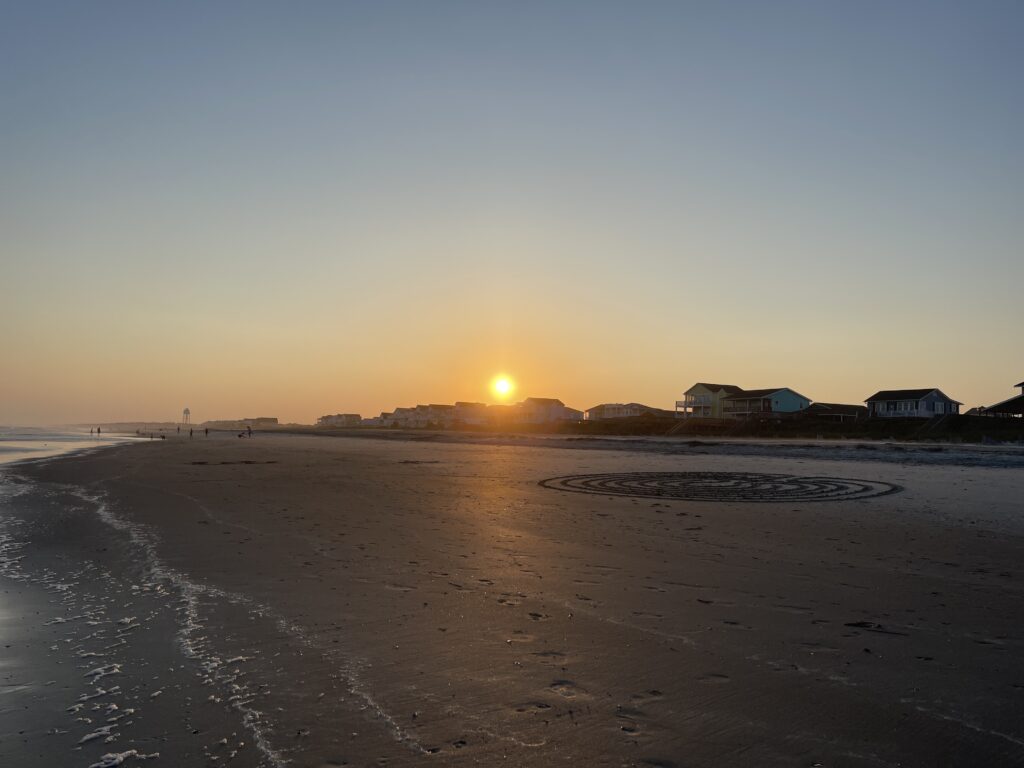 The sun above the beach houses of Holden Beach, North Carolina, as it slowly sets for the evening. 