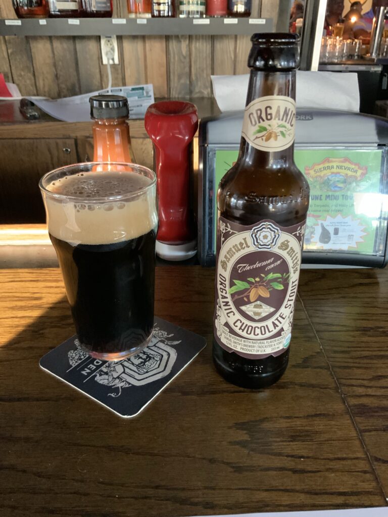 A glass of Sam Smith Organic Chocolate Stout on the bar at the Winking Lizard. The beer’s bottle is to the right of the glass. 