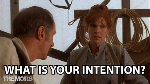 A GIF from the movie Tremors. One person is asking the other “What are your intentions?” The people appear to be in a storage area, with coiled ropes and other tools hanging from wall hooks.